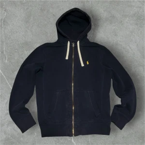 Marinblå hoodie från Polo Ralph Lauren - 📍Storlek:S  💪🏽Skick:Mycket bra   📐Mått:Längd:61:cm:Bred:43:cm:  📎Material:84%Bomull:16%polyester  📦Skickar alltid inom 48h  ✅Äkthetsgaranti  