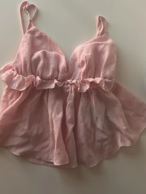 Rosa volang topp med smala axelband - Söt ljusrosa topp med volangdetalj