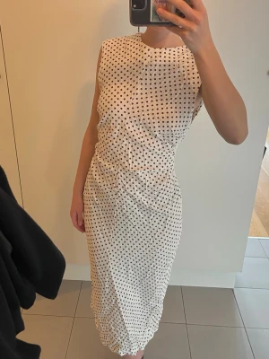 Prickig Zara klänning  - Säljer denna vita linneklänning med svarta prickar, från Zara. Aldrig använd och prislappen kvar💞storlek M