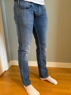 Replay Dave slim fit - Säljer ett par blå jeans med rak passform och klassisk femficksdesign. Jeansen har normalhög midja och subtila slitningar för en avslappnad look. Tillverkade i denim med lätt stretch för extra komfort. Är 185 och sitter bra