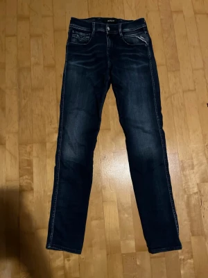 Mörkblå replay anbass jeans - Snygga mörkblå jeans från replay. Klassisk femficksmodell och normal midja. Jeansen har en modern passform och är perfekta för en trendig look. Materialet är denim med stretch för extra komfort. Storlek är W30 L32. Skriv vid frågor.