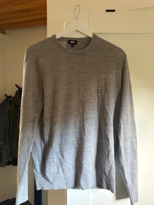 Ljusgrå stickad tröja från Uniqlo - Säljer en stilren ljusgrå stickad tröja från Uniqlo. Tröjan har rund halsringning och långa ärmar. Perfekt basplagg som funkar till allt och är riktigt skön tack vare det mjuka stickade materialet.