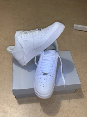 44,5 nya Nike Airforce 01 vit - Säljer för att behövde Nike Airforce 01 akut i butik fanns det bara 44,5 jag har 45,5 så köpte dom endå oavsett dom va 1 storlek mindre sen testa så va det ingen skön känsla orkade inte gå tillbaka och lämna dom för bor långt ifrån butiken en sko med skön mjuk Shoe crease mjuk kan kännas som 44 med Shoe crease för uttrymet minskas med crease. Skorna har perforerad tå, vita skosnören och material i läder. Perfekta för en clean och stilren look. Passar till det mesta och är ett måste i garderoben.