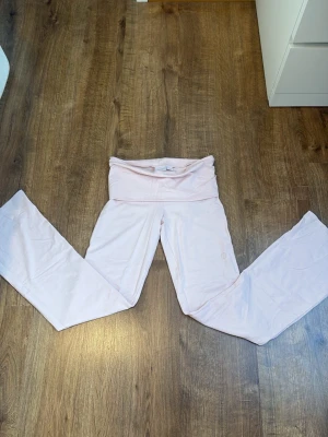 Ljusrosa leggings från Gina Tricot - Supersköna ljusrosa leggings från Gina Tricot med bred midja och raka ben. Perfekta för en avslappnad stil och tillverkade i mjukt stretchigt material som sitter bekvämt hela dagen. Helt nya aldrig andävnda hitta dem i garderoben och kom ihåg jag andvände aldrig dem så jag säljer de 