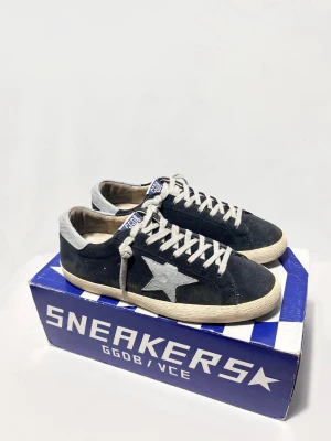 Golden Goose Sneakers - Skorna är i mycket fint skick utan några större defekter. Tillverkade i premiumläder och mocka med Golden Goose klassiska handgjorda vintage-look. Färgen är mörkgrå/blå. Endast skor.  ✔️ Storlek: 41 ✔️ Skick: Mycket fint skick ✔️ 100 % original                                                                    Kontakta mig för fler frågor och funderingar!