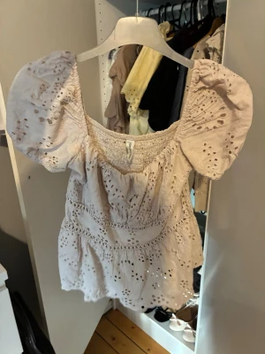 Beige blus med puffärm och broderi - Supersöt beige blus med puffiga korta ärmar och broderade detaljer. 