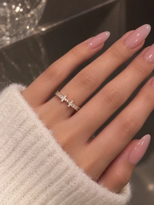 Guldfärgad ring med små pärlor - Trendig guldfärgad ring dekorerad med små vita pärlor och gnistrande stenar. Ringen har en elegant och modern design med dubbla band som möts i mitten. Perfekt accessoar för att lyfta din stil.