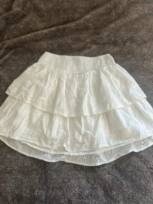 Vit volangkjol från Gina Tricot - Söt vit kortkjol från Gina Tricot med broderade detaljer och volanger. 