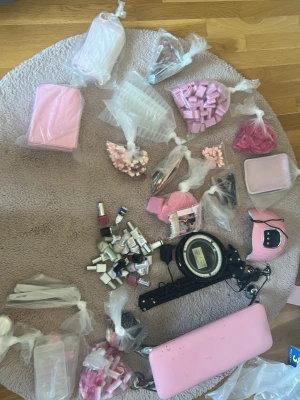 Nagelkitt, armstöd, nagellack, gellack, uvlampa och bordslampa ingår. ( pris kan diskuteras ) Munskydd ingår också men får ej plats i beskrivning. - I detta kit hittar du 14 påsar med tillbehör för naglar. 1- underlägg, 2- svarmpar för ombre, ögonskugga tussar för ombre eller krom och elfilssandpapper i 2 storlekar.  3- Swatches, pappersunderlägg för förlångning med polygel och övningsnaglar för övningshand ( ingår )  4- Nageltippar,  5- Buffar, 6- olika penslar och dotting tools,  7- Plastunderlägg för naglar,  8- Metallbricka för verktyg,  9- Rosa Pads,  10- Krom och glitter,  11- Nagelborstar, 12- Dekoration, 13- Akrylpulver, 14- Filar.