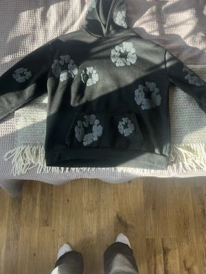 Svart hoodie från Denim Tears - Tjena! Jag säljer en helsvart denim tears hoodie i storlek M men kan säkert passa large också. Priset är inte hugget i sten och kan prutas ner lite vid snabbaffär. Om ni har några frågor så är det bara att skicka i dm. Obs! Hoodien är lite sönder på den högra delen av fickan och är lite knopprig. Annars är hoodien i bra skick👍🫡