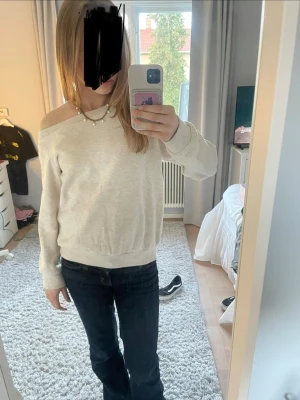 Off shoulder ljusgrå sweatshirt - Trendig ljusgrå off shoulder sweatshirt med avslappnad passform och bred mudd vid midjan. Långa ärmar och mjukt material, perfekt för en chill och stilren look. Inga synliga loggor eller märken. Storlek står inte men skulle säga  på xs-s❤️