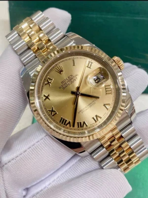 Rolx DateJust  - En elegant Rolx Datejust med ett klassiskt tvåfärgat armband i guld och silver. Urtavlan är champagnekulör med romerska siffror och datumfönster. Klockan har en räfflad bezel och en elegant design som verkligen sticker ut. En lasergraverad logotyp är placerad vid klockan sex, och på boettens baksida finns en stämplad logotyp i varje hörn✅. Mekanisk klocka.                      Fast shipping✅