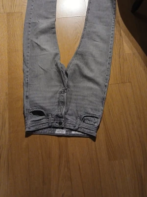 Grå raka jeans från Weekday - Snygga grå jeans från Jack and jones modell loose/ Chris rak passform och klassisk modell. Jeansen har en ljusgrå tvätt och är tillverkade i bomull. Perfekta för en avslappnad och trendig look.