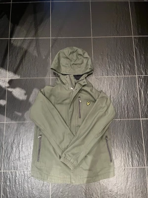 Grön vindjacka från Lyle & Scott - En lyle and scott jacka som är tunn perfekt till våren eftersom det börjar bli lite varmare, jackan har inga skador alls och är använd 1-3 gånger.