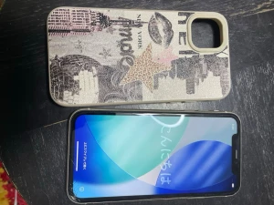 iPhone 11 och skal New York motiv beige - Snyggt mobilskal till iPhone med beige bakgrund och New York-inspirerat motiv. Skalet har tryck av stadssilhuett, stjärna, läppar och text. Materialet är konstläder med struktur och skalet har öppning för kamera. Perfekt för dig som vill ha ett unikt och trendigt skydd till mobilen.