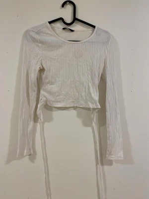 Tröja med knytning i ryggwn - Okänt märke, kort tröja. Vet inte storlek men passar xs-s