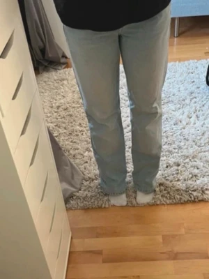 Ljusblå raka jeans - Säljer ett par ljusblå jeans med rak passform och klassisk femficksdesign. Jeansen har normal midja och är tillverkade i denim. Perfekta för en avslappnad och trendig look.