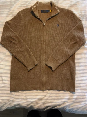 Brun ziptröja från Polo Ralph Lauren - Säljer min underbara Polo zip som är utan luva som är gjord med fin mönster. Den är väldigt bekväm och snygg och passar med allting. Den är i storlek M  Vid några funderingar är det bara att höra av sig☺️