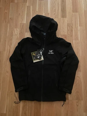 Svart regn jacka  - Perfekt regn samt vind jacka i färgen svart med märket arc’teryx. Perfekt för en regnig sommar samt vindig beroende på hur vädret blir. Storlek medium och sitter true to size.