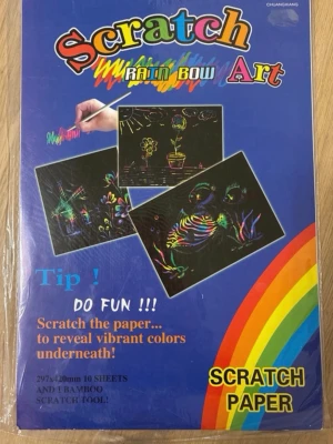 Scratch Art regnbågspapper 8-pack - Ett paket med 8 ark svart scratch paper i storlek 297x420 mm (A3) från Chuangxiang. Skrapa ytan med medföljande bambupinne för att avslöja färgglada regnbågsmönster under. Perfekt för kreativa projekt och teckningar.