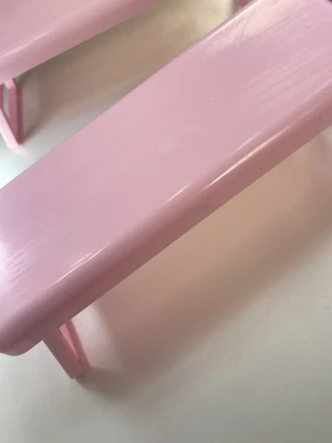 Rosa nagelarmstöd  - Säljer ett rosa nagelarmstöd med enkel, rektangulär form och vikbara ben. Perfekt för att vila handen vid nagelfix och gör det lättare att måla eller dekorera naglarna hemma eller i salong.