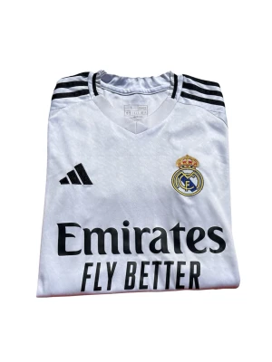 Real Madrid Adidas AEROREADY Matchtröja Stl S - Real Madrid-tröja från Adidas med AEROREADY. Storlek S. Fint skick utan hål eller större skador. Perfekt för fotboll, träning eller supporter. Lite knoppig bara men funkar galant!