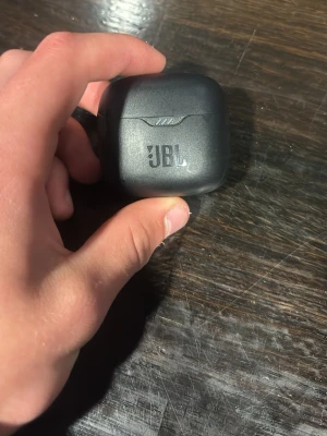 JBL svarta trådlösa in-ear hörlurar - Säljer ett par svarta trådlösa in-ear hörlurar från JBL med laddningsetui. Snygg och kompakt design i matt plast, perfekt för musik och samtal på språng. Laddningsetuiet har JBL-logga och hörlurarna har LED-indikatorer.