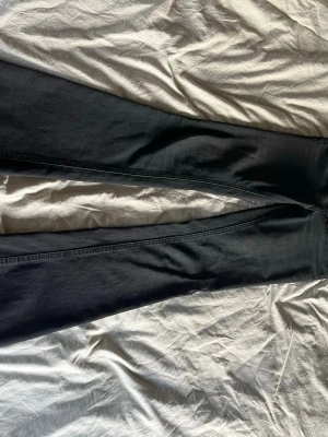 Svarta bootcut jeans - Säljer ett par svarta bootcut jeans med klassisk femficksdesign. Jeansen har en snygg passform som är smal upptill och utsvängda nedtill. Materialet är denim med stretch för extra komfort. Perfekta för dig som gillar en tidlös och cool stil. Jag har sprättat upp de nertill, se sista bilden💕 storlek xs/tall