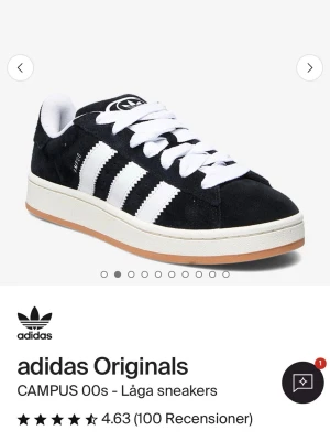 adidas Originals Campus 00s sneakers - Snygga adidas Originals Campus 00s sneakers i svart mocka med klassiska vita ränder och vit sula. Skorna har breda vita skosnören och en retro look som passar perfekt till streetwear. Yttersulan är ljusbrun och insidan är vit.