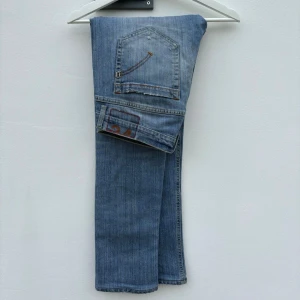 Dondup George - Tja! Ljusblåa jeans från Dondup i modellen; ”George”. Marknadens hetaste jeans just nu med slitningar ifrån fabrik. (Size: 34)  (Skick: 4/5)  (Retail: 3500kr)  (Vårt pris: 799kr). (Mått: A = 42cm, B = 26cm, C = 77cm). Hör av er vid frågar & funderingar. /Mvh, Morëtti Co.