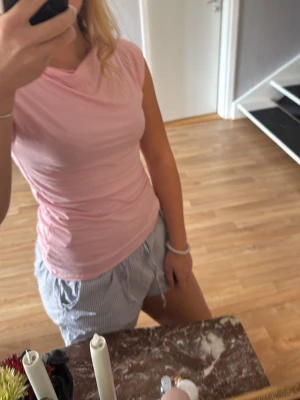 Ljusrosa ärmlös topp - Snygg ljusrosa ärmlös topp med rund halsringning. Toppen är figurnära och passar perfekt till sommaren. Tillverkad i mjukt och stretchigt material som känns skönt mot huden.