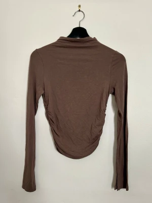 Soft touch topp från Gina - Långärmad med liten polokrage! Jättesnyggt insydd på sidorna :)