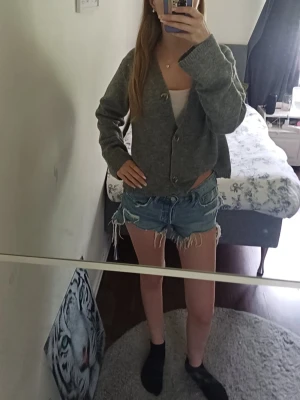 Blå jeansshorts med fransar - Säljer ett par blå shorts, fransiga kanter. Shortsen har låg midja och slitna detaljer för en avslappnad look. Perfekta för varma dagar och enkel att matcha med olika toppar. storlek 38 men passar även min som vanligt vis har 36 men dom är lite stora på mig. 