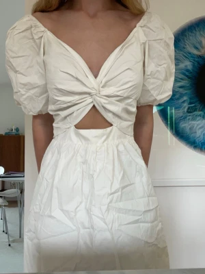 Vit klänning från H&M - Vit v-ringad klänning från H&M med twist detalj och cutout🤍Helt ny med lappen kvar🤍 Str S och var lite för stor för mig som är 165 cm🤍 Säljer då jag inte hann lämna tillbaka den och den var lite stor🤍