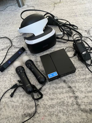 Sony PlayStation VR-kit med tillbehör - Komplett PlayStation VR-kit med svart och vitt VR-headset, två svarta Move-kontroller, kamera och processorenhet. Allt är i plast och designat för PS4. Perfekt för att uppleva VR-spel på riktigt. Inga spel ingår, allt är väldigt lite använt. 