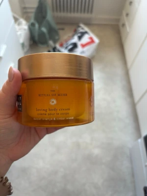 Rituals Mehr body cream - Rituals The Ritual of Mehr loving body cream med doft av söt apelsin och cederträ. Kommer i en rund, orange plastburk med guldigt lock. Perfekt för att återfukta huden och ge en fräsch känsla.