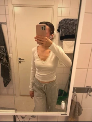 Topp från Gina Tricot - Långärmad vit topp med spetskant från Gina Tricot. Använd fåtal gånger. Nypris: 249-299kr