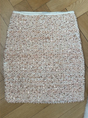 Paljettkjol från Vila - Supersnygg kort kjol täckt med glittriga paljetter i champagnefärg/ljusrosa. Tight passform med mycket stretch, jag brukar ha xs/s och denna i stl M passar mig. 
