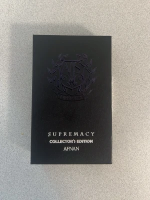 Afnan Supremacy Collector's Edition - Supremacy Collector's Edition från Afnan är en exklusiv parfym i en stilren, gråspräcklig flaska med svart emblem och lock. Förpackningen är svart med silvertext och har en lyxig känsla, perfekt för dig som gillar unika dofter och snygg design.