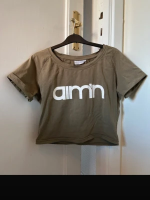 T-shirt - Militärgrön T-shirt från Aim'n med vitt tryck. Mycket fint skick. Material: Bomull
