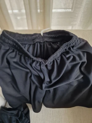 Svarta loose shorts med resår - Säljer ett par svarta shorts med loose passform och elastisk resår i midjan. Perfekta för dig som vill ha något bekvämt och enkelt.