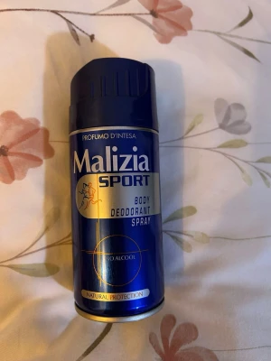 Malizia Sport Body Deodorant Spray - Malizia Sport Body Deodorant Spray i en blå metallburk med gulddetaljer. Sprayen är alkoholfri och ger naturligt skydd. Praktisk och enkel att använda, perfekt för dig som vill hålla dig fräsch hela dagen.