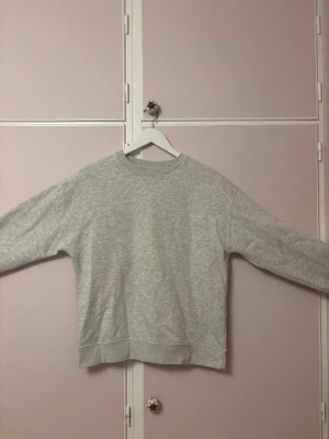 Ljusgrå basic sweatshirt - En  ljusgrå sweatshirt i mjukt material. Tröjan har rund halsringning, långa ärmar och ribbade muddar vid ärmslut och nederkant. Perfekt för en avslappnad och clean look. Storlek 164 / 13-14 men eftersom att den är oversized kan den passa xs. 
