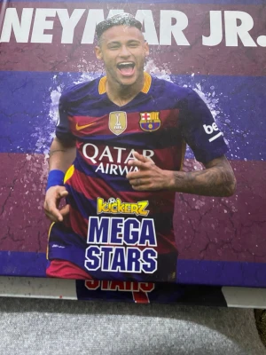 Kickerz Mega Stars Neymar JR bok - En färgstark bok om fotbollsstjärnan Neymar JR från serien Kickerz Mega Stars. Omslaget har lila och röda toner med bilder på Neymar i FC Barcelona bok . Perfekt för dig som gillar fotboll och vill veta mer om en av världens största spelare.