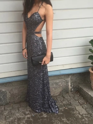 Balklänning  - Säljer denna otroliga balklänningen som är köpt hos Dressroom Linné i Göteborg för 5000 😍Den är helt täckt av paljetter och har smala justerbara axelband med cut-out i midjan, samt ett band runt midjan och öppen rygg 🫶 Den är endast använd en gång så i perfekt skick! Den är i storlek 34 (xs) men kan även passa en 36 (s). Den är uppfållad framtill med ett par enkla handgjorda stygn som enkelt kan tas bort om man önskar. Passar perfekt för bal, sittningar, bröllop eller liknande 💛Dressbag ingår 