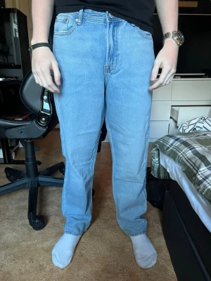 Blå raka jeans - Säljer ett par klassiska ljusblå jeans från Jack & Jones med rak passform och fem fickor. Jeansen är i storlek 170 och är i modellen Relaxed Chris. Dem är helt nya och har prislappen kvar.