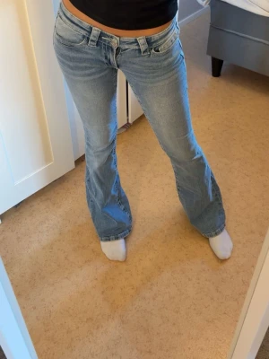 Ljusblåa bootcut jeans från gina tricot - Säljer ljusblåa jeans från gina tricot young med tryck på bakfickorna med stenar. Säljs då de inte kommer till någon använding. Finns kvar tills markerat sålt!💓