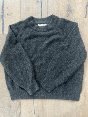 Mörkgrå stickad tröja från Pull&Bear  - Mysig mörkgrå stickad tröja från Pull&Bear. Skön ”slänga på” tröja med en slits på båda sidorna💗🌸