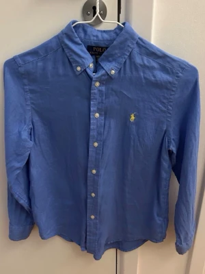 Blå skjorta från Polo Ralph Lauren för barn, storlek M 10-12 år - Linne skjorta från Polo Ralph Lauren som användes vid få tal tillfällen och i mycket fint skick. 