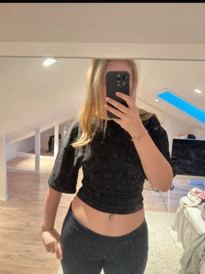 Svart topp  - Snygg svart croppad topp med halvärm och tight passform. Perfekt till jeans eller kjol för en trendig look. Enkel och stilren design utan mönster eller detaljer. Gjord i mjukt material som sitter skönt på kroppen.